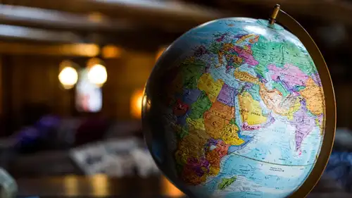 A desk globe lit by a lamp in a quiet room